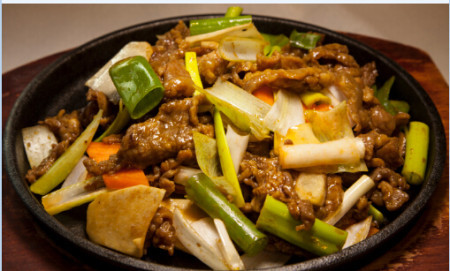 Ginger and onion lamb stir fry on sizzling plate