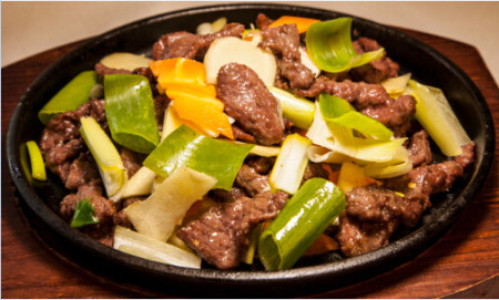 Ginger and onion beef stir fry on sizzling plate